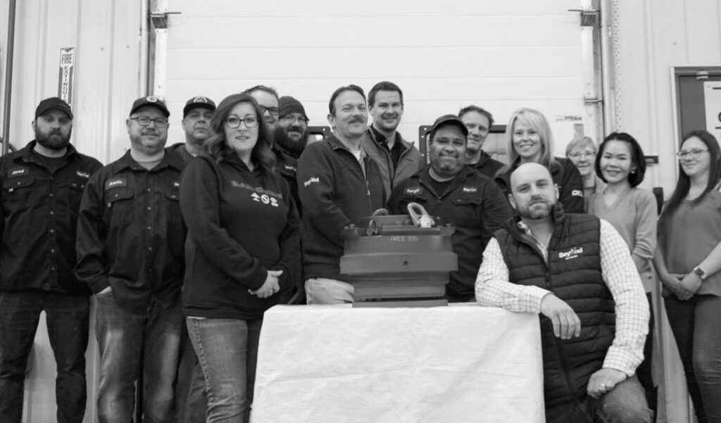 Group of Beyond employees standing around a piece of equipment on a table.